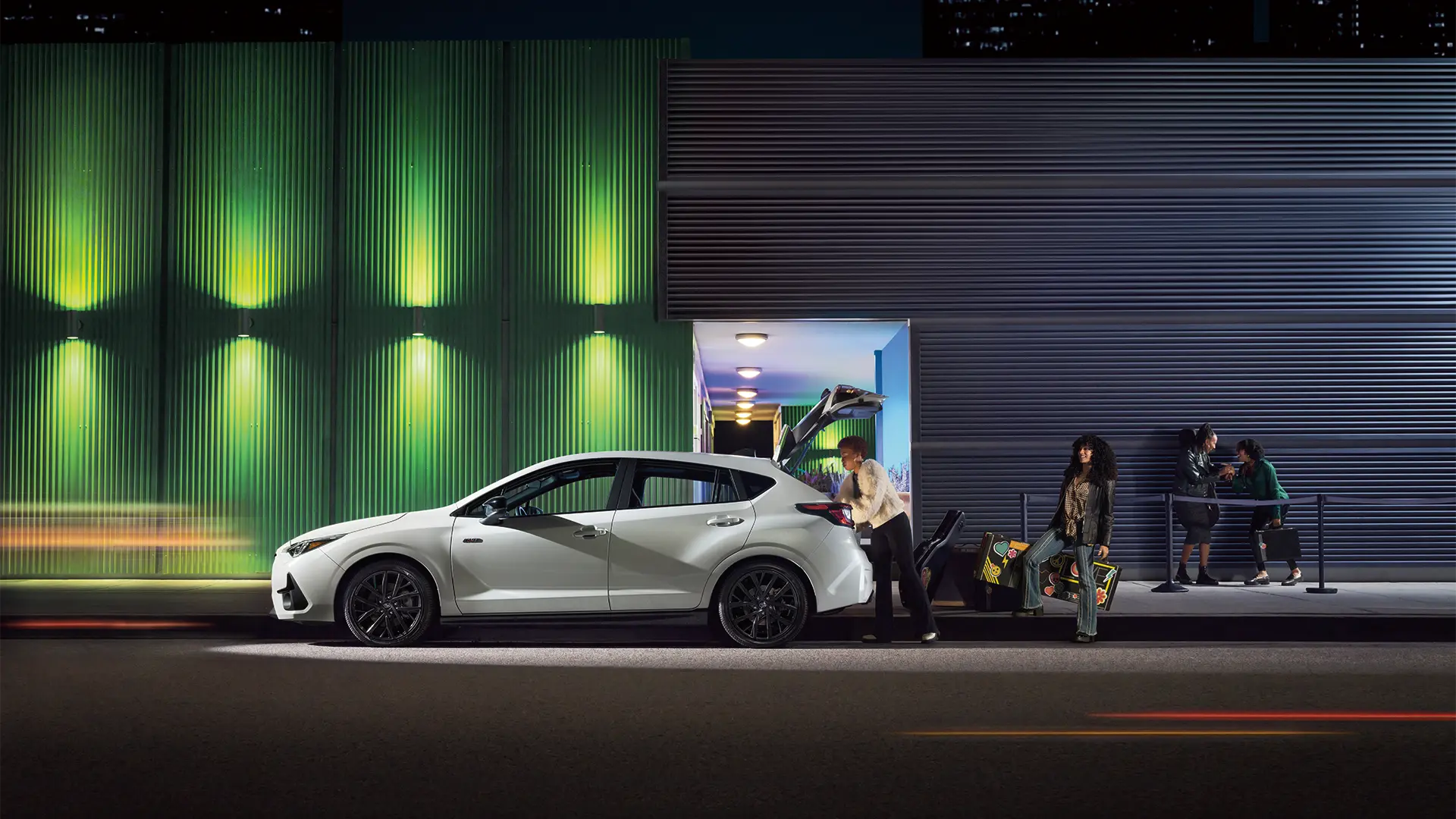 The 2026 Impreza Sport parked on side of road at night.
